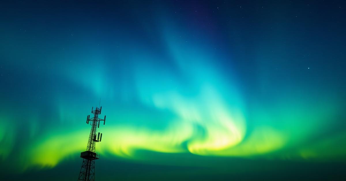 A silhouetted radio tower under a green and blue aurora, symbolizing ionospheric propagation
